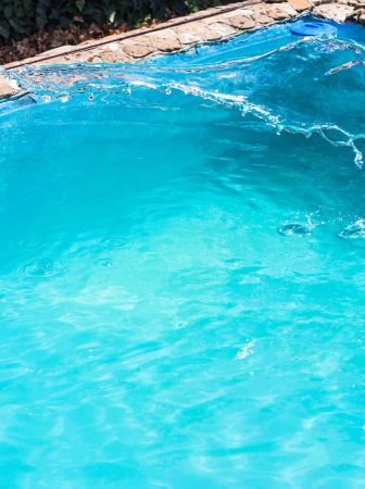 splashing of disinfectant in outdoor swimming pool on backyard of country house